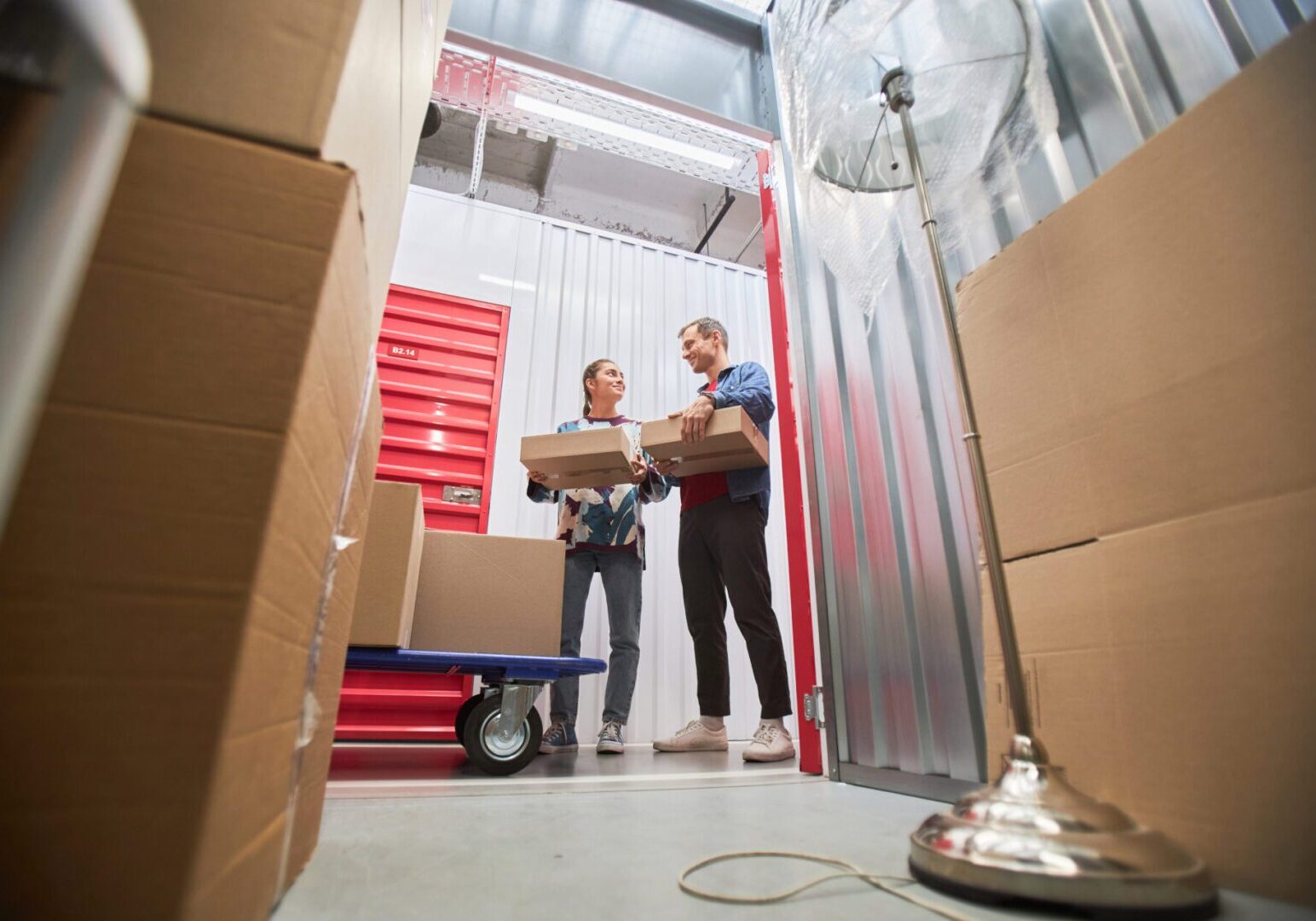 Couple Renting Unit at Self-Storage Two people organizing boxes in storage unit.